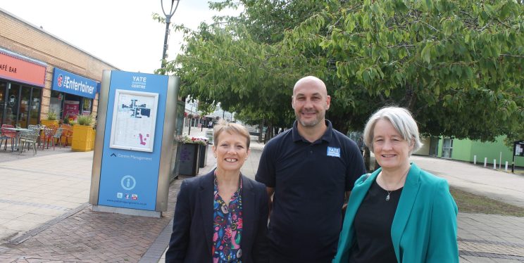 Clare stood with two other people in front of a sign with a map of Yate on it