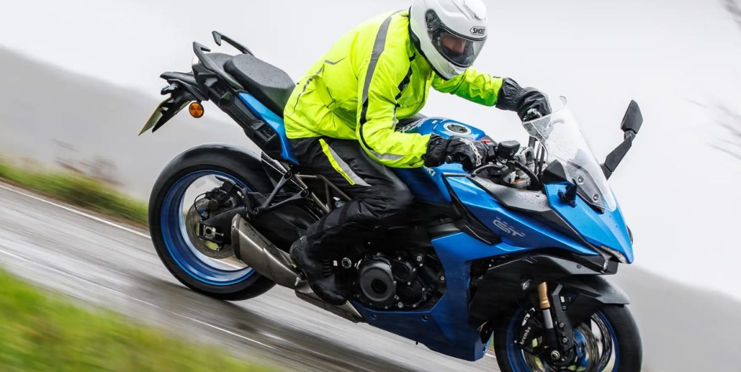 A man wearing a helmet and high-vis jacket riding a motorbike