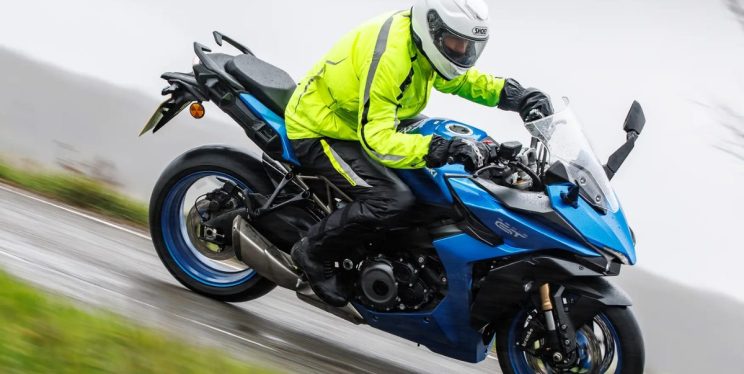 A man wearing a helmet and high-vis jacket riding a motorbike
